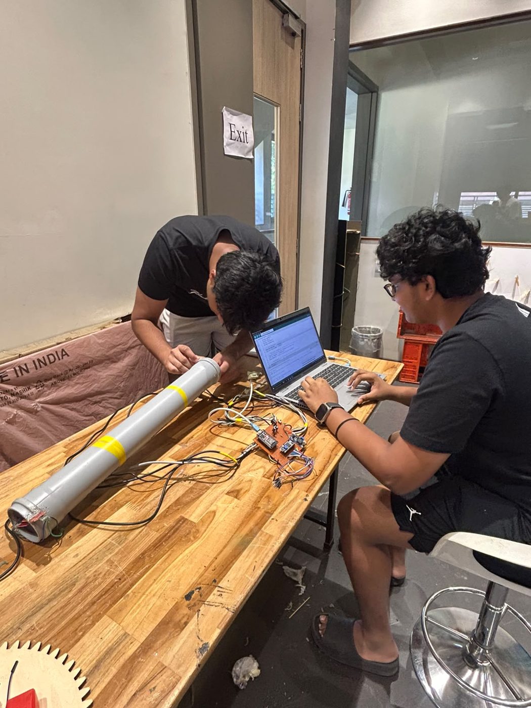 Two team members bench-testing the sensor pipe with a laptop